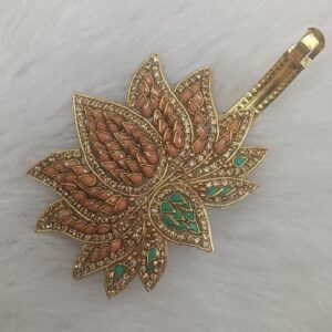 Gold-tone lotus design barrette hair clip with orange and green enamel detailing on a soft background