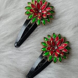 Red and green enamel floral tic tac hair clips with gold detailing and rhinestone center on a black clip base.