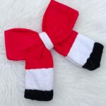 Red, white, and black Santa-themed bow hair clip on a white background.