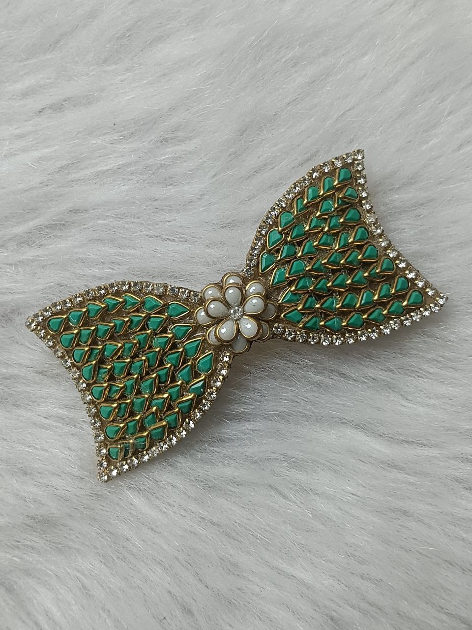 Green Kundan Bow Design Gold-Tone Barrette Hair Clip Gold-tone green Kundan bow hair clip with floral center accent on soft background