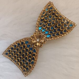 Gold-tone blue Kundan bow hair clip with floral center accent on soft background