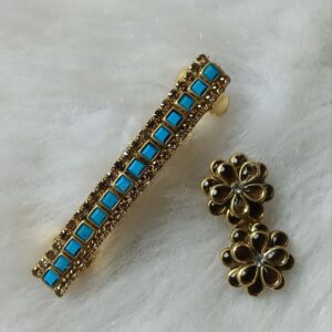 Blue kundan saree pin and matching floral hair clip in gold tone with square stones on a soft white background
