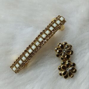 White kundan saree pin and matching floral hair clip in gold tone with square stones on a soft white background